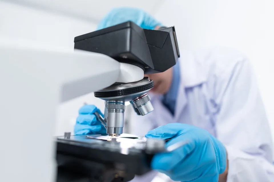 Laboratory professional using a microscope